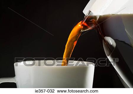 Stock Image - A cafetiere pouring coffee into cup. Fotosearch