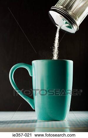 Stock Image - Pouring sugar into a coffee cup. Fotosearch