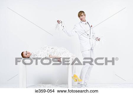 A businessman covering a businesswoman in shredded paper View Large Photo Image Picture - A businessman covering a businesswoman in shredded paper. Fotosearch