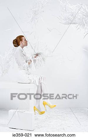 Stock Image - A businesswoman holding shredded paper. Fotosearch