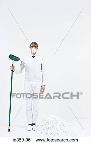 Stock Image - A man holding a broom. Fotosearch