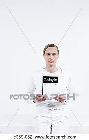 Stock Image - A man holding a notebook. Fotosearch