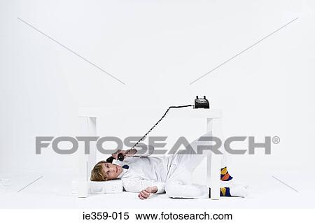 A man using a phone under a desk View Large Photo Image Stock Photography - A man using a phone under a desk. Fotosearch