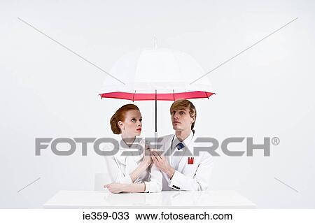 Businesspeople holding an umbrella View Large Photo Image Stock Image - Businesspeople holding an umbrella. Fotosearch