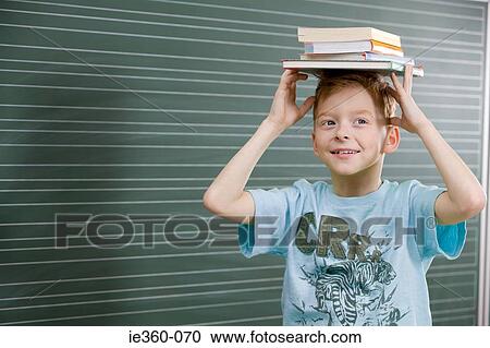 Boy with books on his head View Large Photo Image Stock Image - Boy with books on his head. Fotosearch