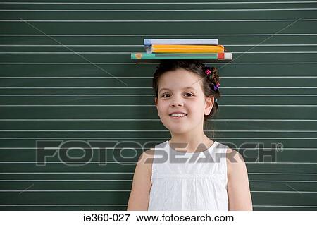 Girl with books on her head View Large Photo Image Stock Photo - Girl with books on her head. Fotosearch