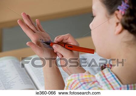 Girl writing on her hand View Large Photo Image Stock Photograph - Girl writing on her hand. Fotosearch