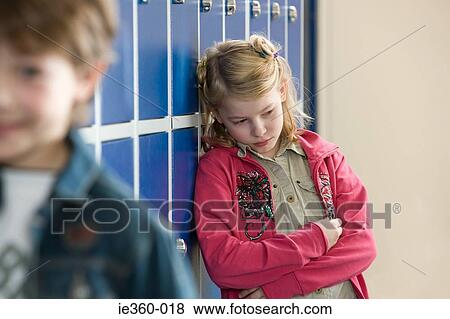 Sad girl in school corridor View Large Photo Image Stock Photo - Sad girl in school corridor. Fotosearch