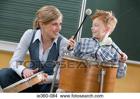 Teacher and boy playing drum View Large Photo Image Picture - Teacher and boy playing drum. Fotosearch