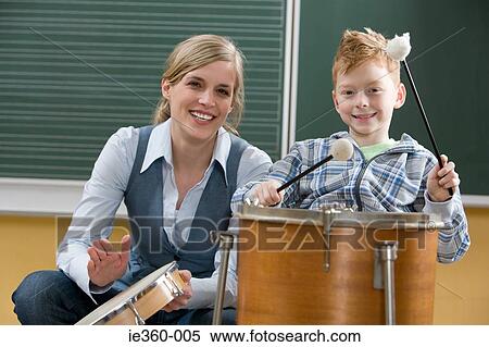 Teacher and boy playing drum View Large Photo Image Stock Photography - Teacher and boy playing drum. Fotosearch