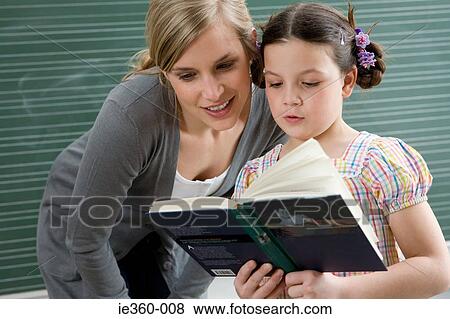 Teacher and girl reading View Large Photo Image Stock Photo - Teacher and girl reading. Fotosearch