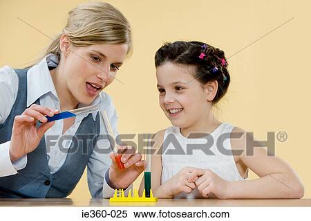 Stock Photography - Teacher and girl with test tubes. Fotosearch