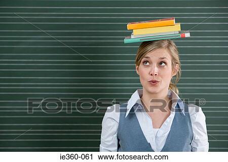 Teacher with books on her head View Large Photo Image Stock Image - Teacher with books on her head. Fotosearch
