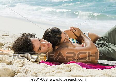 A teenage couple lying on the beach View Large Photo Image Stock Image - A teenage couple lying on the beach. Fotosearch