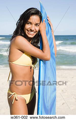Portrait of a teenage girl holding a surfboard View Large Photo Image Stock Image - Portrait of a teenage girl holding a surfboard. Fotosearch
