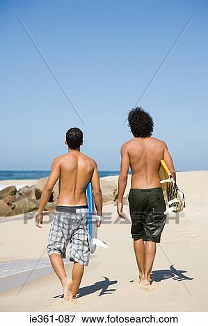Rear view of teenage boys walking along the beach View Large Photo Image Stock Photo - Rear view of teenage boys walking along the beach. Fotosearch