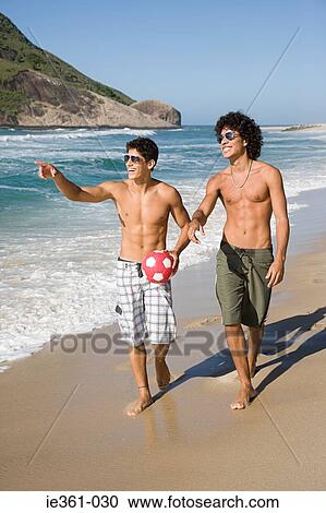 Teenage boys walking along a beach View Large Photo Image Stock Image - Teenage boys walking along a beach. Fotosearch