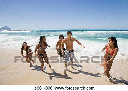 Teenagers fooling around on the beach View Large Photo Image Stock Photograph - Teenagers fooling around on the beach. Fotosearch