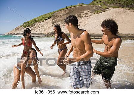 Teenagers fooling around on the beach View Large Photo Image Stock Photograph - Teenagers fooling around on the beach. Fotosearch