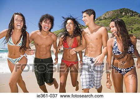 Teenagers running along a beach View Large Photo Image Stock Photo - Teenagers running along a beach. Fotosearch