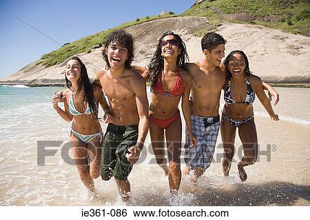 Teenagers running along a beach View Large Photo Image Stock Photograph - Teenagers running along a beach. Fotosearch