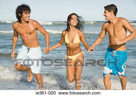 Teenagers running along the beach View Large Photo Image Stock Image - Teenagers running along the beach. Fotosearch