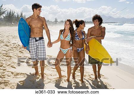 Teenagers walking along a beach View Large Photo Image Stock Image - Teenagers walking along a beach. Fotosearch