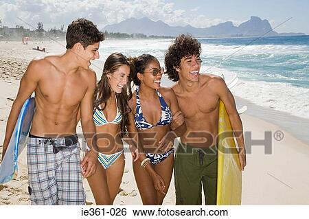 Teenagers walking along a beach View Large Photo Image Stock Photograph - Teenagers walking along a beach. Fotosearch