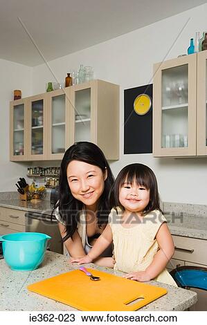 A daughter helping her mother in the kitchen View Large Photo Image Stock Image - A daughter helping her mother in the kitchen. Fotosearch