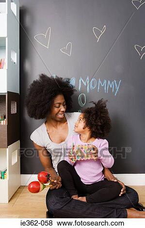 Stock Photo - A mother and daughter playing instruments. Fotosearch