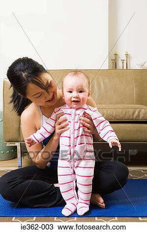A mother holding her baby daughter View Large Photo Image Stock Image - A mother holding her baby daughter. Fotosearch