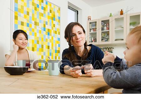 Friends and a baby boy sat in a kitchen View Large Photo Image Stock Image - Friends and a baby boy sat in a kitchen. Fotosearch