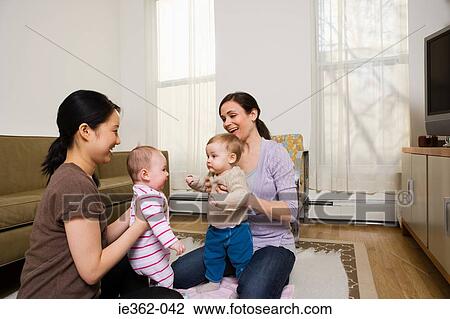Stock Image - Mothers and their babies playing. Fotosearch