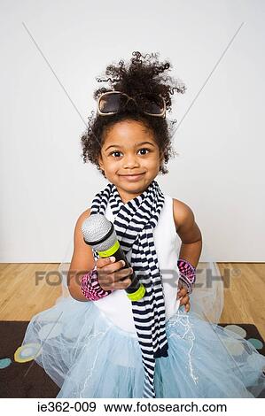 Stock Photo - Portrait of a girl holding a microphone. Fotosearch