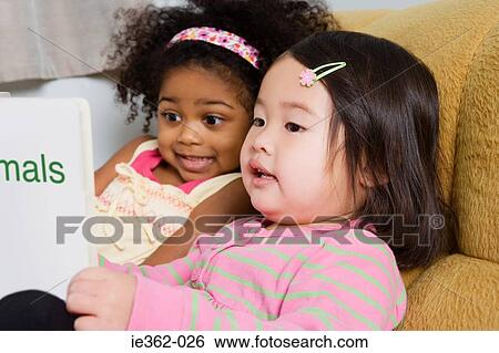 Stock Photograph - Two girls reading a book. Fotosearch