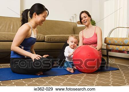 Stock Photo - Two women playing with a baby boy. Fotosearch
