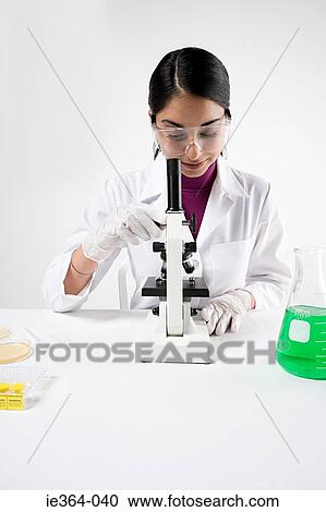 Stock Image - Scientist with microscope. Fotosearch