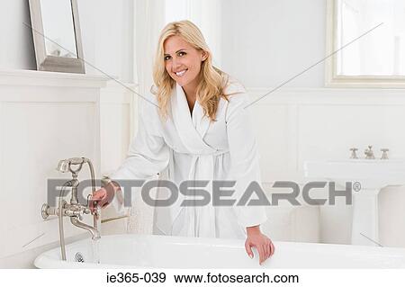 A woman running a bath View Large Photo Image Stock Photo - A woman running a bath. Fotosearch