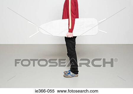 Man holding ironing board like surfboard View Large Photo Image Stock Photography - Man holding ironing board like surfboard. Fotosearch