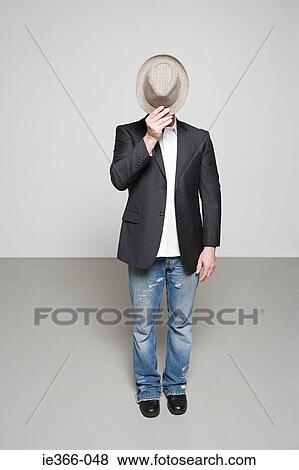 Man with hat in front of face View Large Photo Image Stock Photo - Man with hat in front of face. Fotosearch