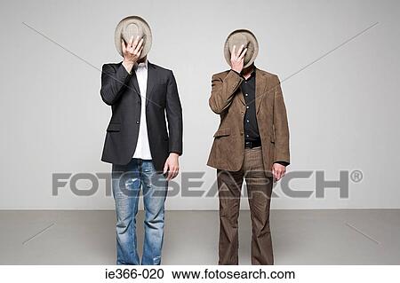 Men holding hats over their faces View Large Photo Image Stock Image - Men holding hats over their faces. Fotosearch