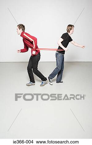 Picture - Two men pulling plastic hoop. Fotosearch