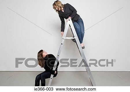 Two women on step ladder View Large Photo Image Stock Image - Two women on step ladder. Fotosearch