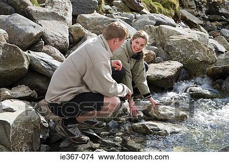 A couple by a river View Large Photo Image Picture - A couple by a river. Fotosearch