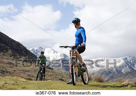 A couple cycling View Large Photo Image Stock Photograph - A couple cycling. Fotosearch