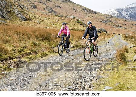 A couple cycling View Large Photo Image Stock Photography - A couple cycling. Fotosearch