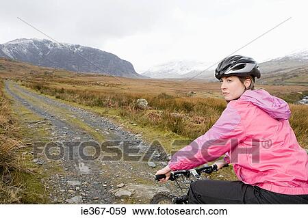 A woman cycling View Large Photo Image Stock Photo - A woman cycling. Fotosearch