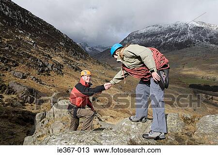 A woman giving a man a helping hand View Large Photo Image Stock Image - A woman giving a man a helping hand. Fotosearch