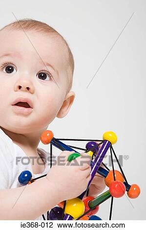 A baby boy holding a toy View Large Photo Image Stock Image - A baby boy holding a toy. Fotosearch