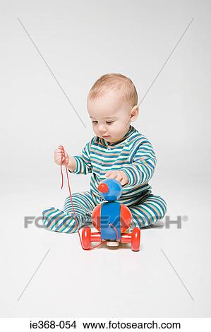 Picture - A baby boy playing with a toy. Fotosearch